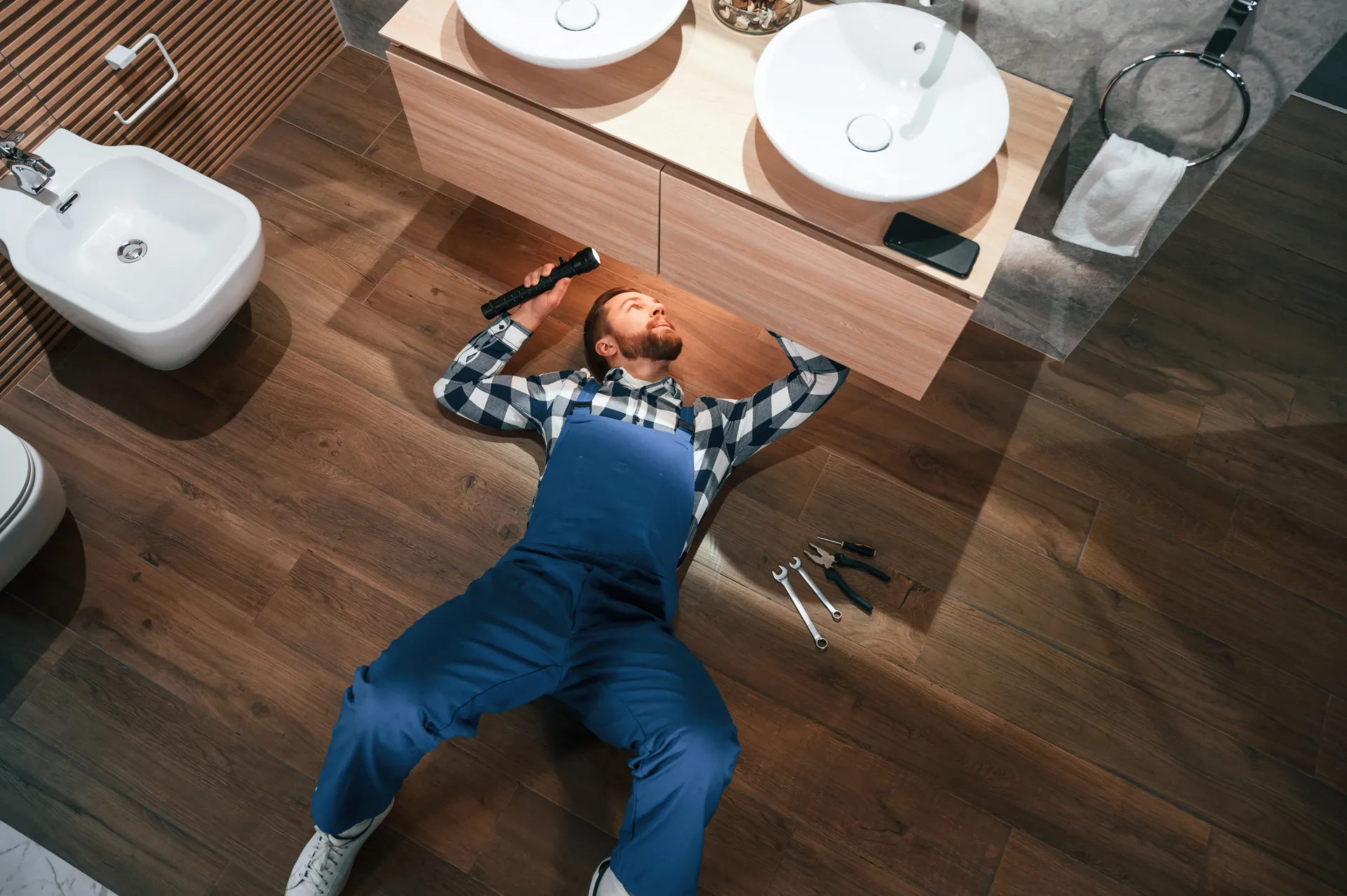 Plumber inspecting under a sink